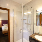 Badezimmer mit Blick auf das Hotelbett